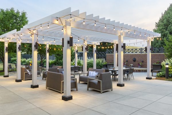 A white pergola with string lights.