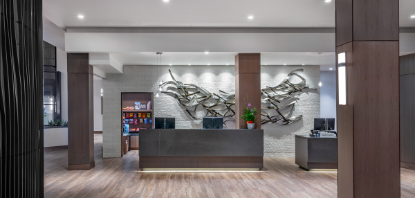 a lobby with a large metal sculpture on the wall.