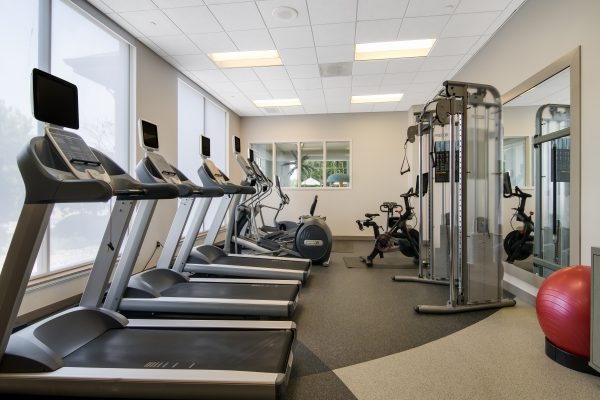 A gym room with treadmills and other exercise equipment.
