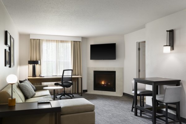 A hotel room with a fireplace and a couch.