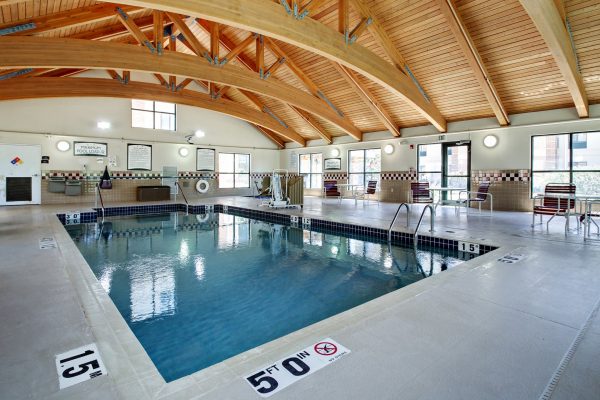 A large indoor swimming pool with a wooden ceiling.