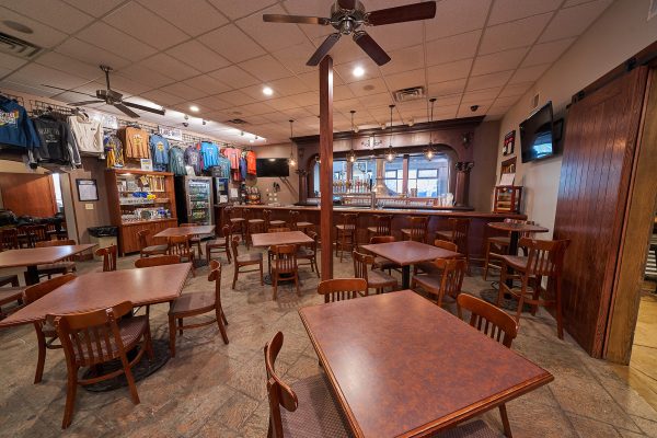 A restaurant with tables and chairs and a ceiling fan.