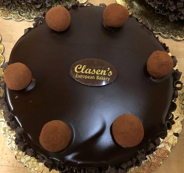 A chocolate cake with chocolate balls on top.