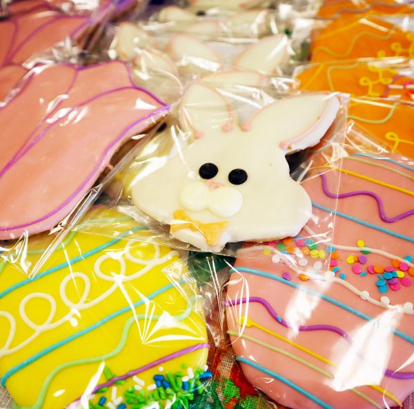 A bunch of easter bunny cookies in plastic bags.