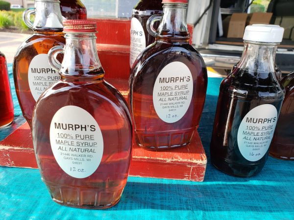 several bottles of murp's maple syrup on a table.