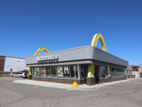 a mcdonald's restaurant with a yellow fire hydrant in front of it.