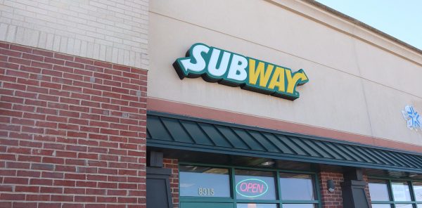 a subway store front with a green awning.