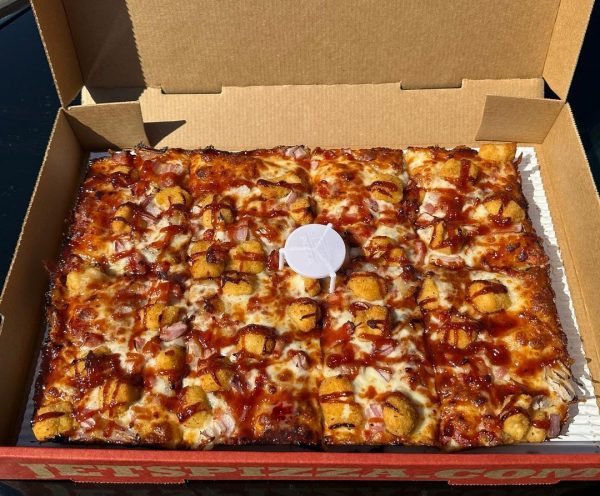 A pizza in a box sitting on a table.
