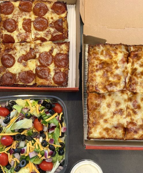A pizza and salad in a box.