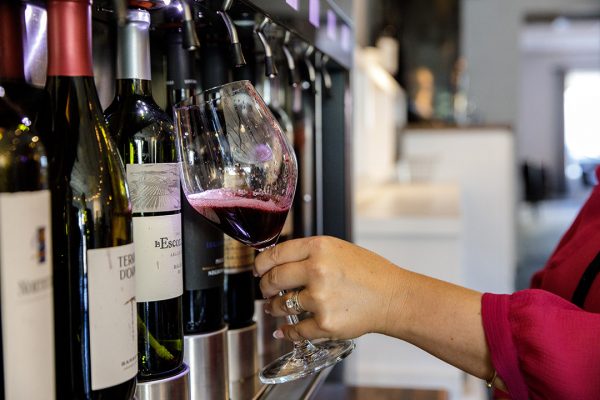 A woman pouring wine into a glass.
