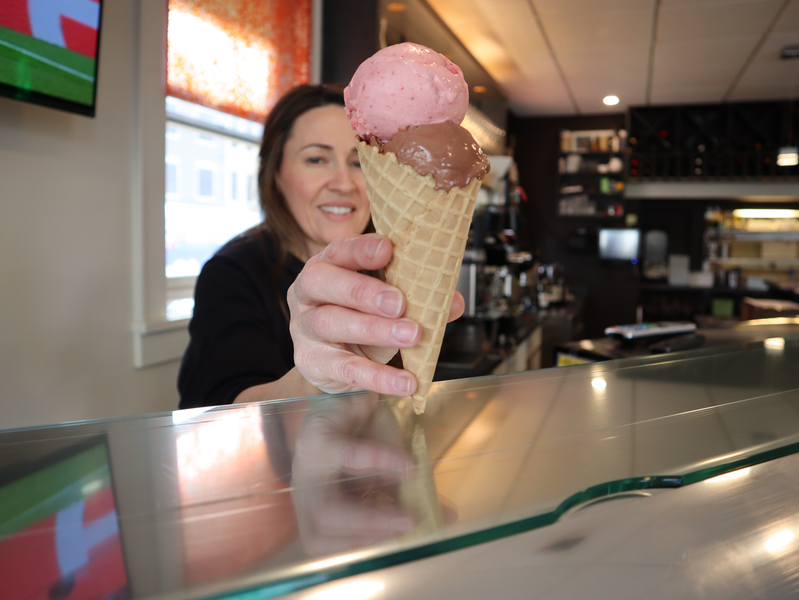 a woman holding up a scoop of ice cream.
