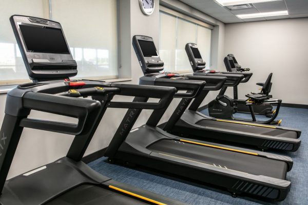 A gym room with treadmills and other exercise equipment.