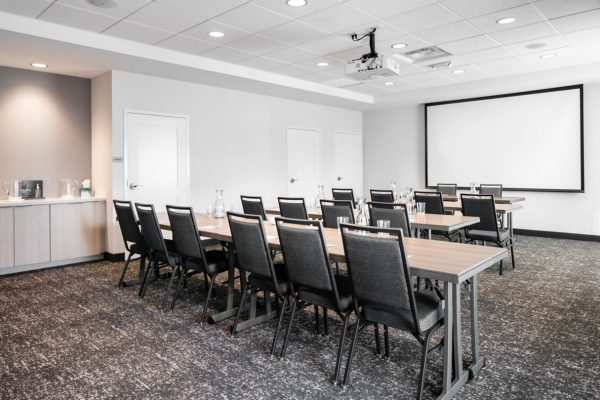 A conference room with chairs and a projector screen.