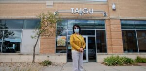 a woman wearing a face mask standing in front of a building