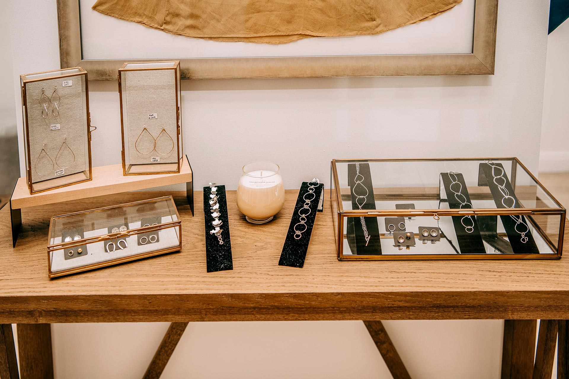 a wooden table topped with a couple of boxes filled with jewelry