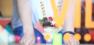 a person holding a martini glass filled with fruit
