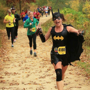 a woman dressed as batman running in a race