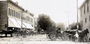a black and white photo of a horse drawn carriage