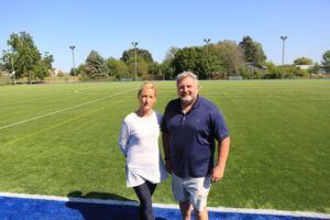 a man and a woman standing on a soccer field