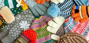 a pile of colorful knitted mittens and gloves