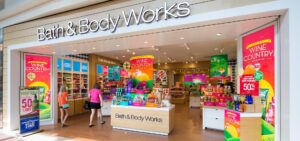 a woman is walking into a bath and body works store