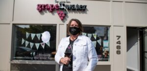 a woman wearing a face mask standing in front of a store