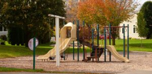 a children's playground with a slide and climbing frame