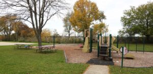 a park with a playground and picnic tables