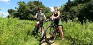 a man and a woman riding bikes on a trail