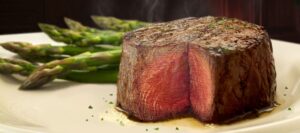 a piece of steak on a plate with asparagus