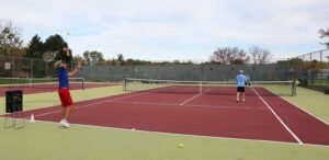 two people playing tennis on a tennis court
