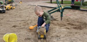 a little boy playing in the sand at a park