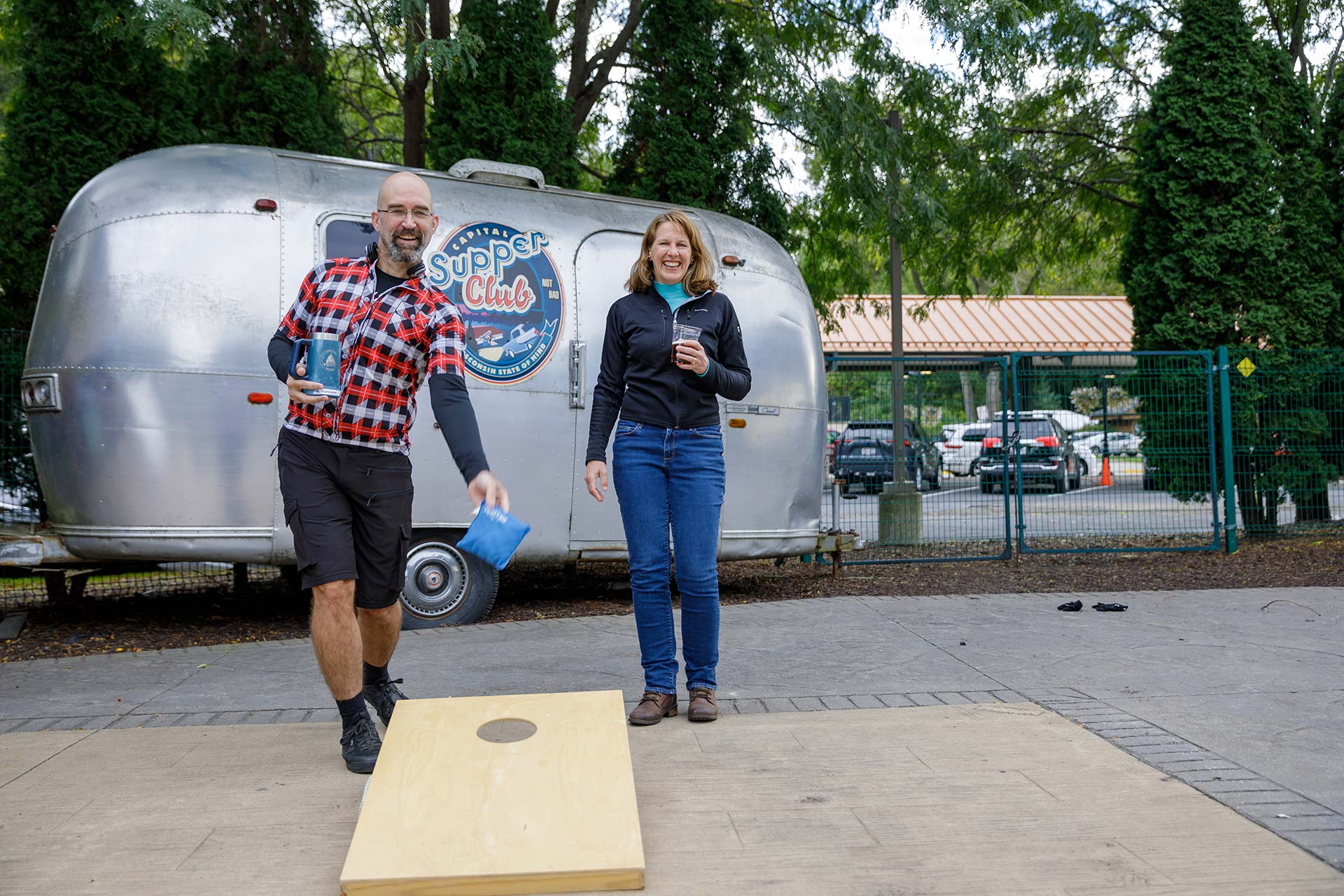 a man and a woman playing a game in front of a trailer