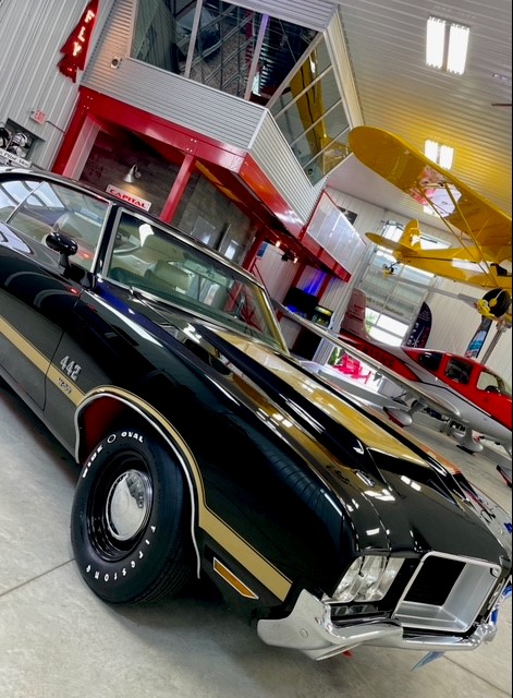 a black and gold muscle car parked in a garage.