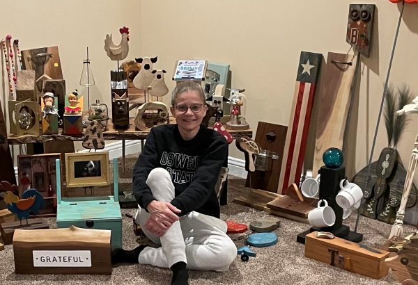 a woman sitting on the floor in front of a collection of wooden items.