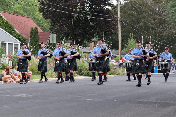 a group of men in kilts marching down a street.