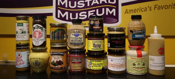a variety of mustards are displayed on a table.