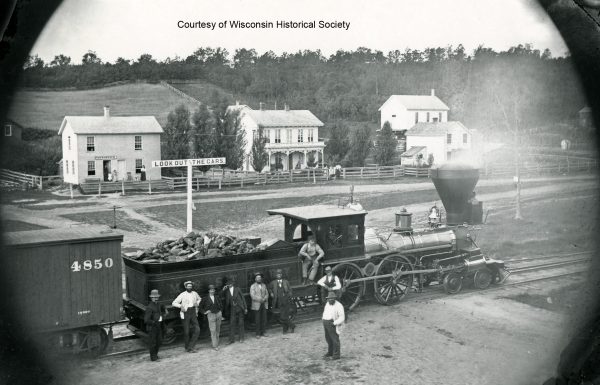 a group of people standing next to a train.