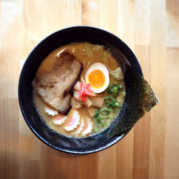 A bowl of ramen with an egg in it.