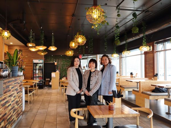 Three women standing in a restaurant.