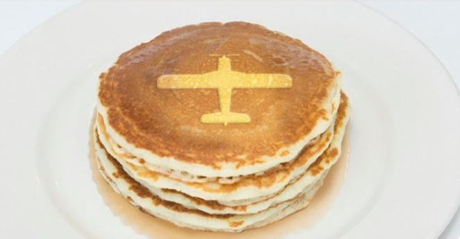 a stack of pancakes with a yellow airplane on top.