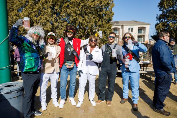 A group of six people in costumes enjoying a sunny day at the Bockfest in Middleton, Wisconsin, casually hold their drinks as they pose for a perfect festival snapshot.