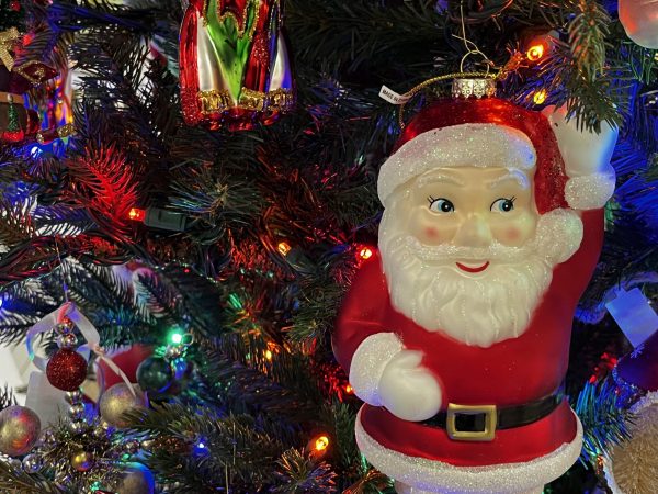 Close-up of a decorated Christmas tree featuring a Santa Claus ornament and colorful lights.