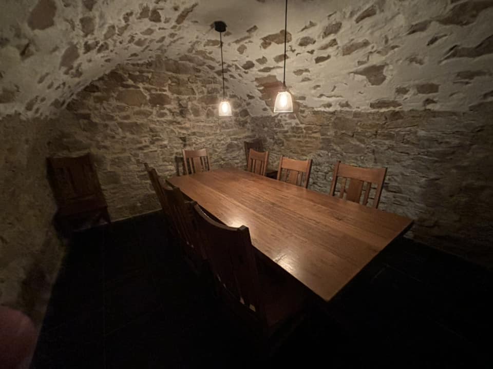 A dining room with a stone wall and a wooden table.