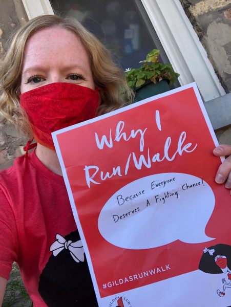 A woman holding a sign that says why i runwalk.