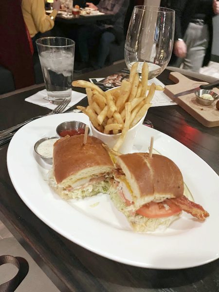 A plate with a sandwich and fries on it.