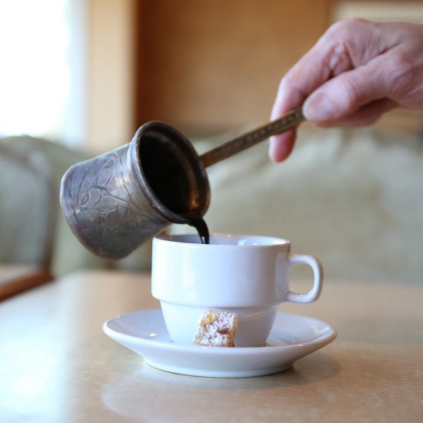 A person pouring coffee into a cup.