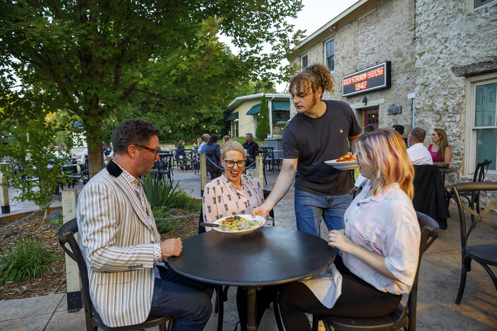 A group of people sitting at a table in an outdoor restaurant.
