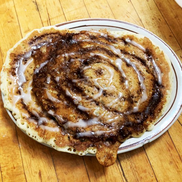 A plate with a cinnamon roll on it.