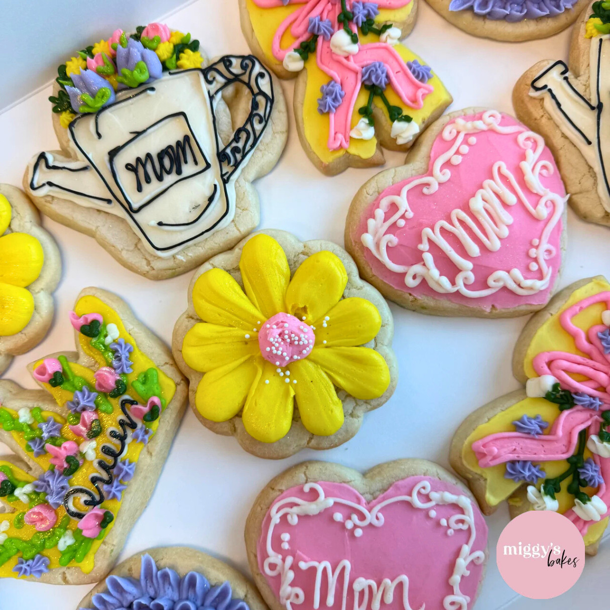 Assorted decorated sugar cookies for Mother's Day, featuring flowers, hearts with "Mom" written on them, and a watering can design—perfect treats for your Mother's Day specials.